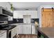 Stylish kitchen showcasing stainless steel appliances, modern backsplash, and white cabinets at 9675 E Kansas Cir # 45, Denver, CO 80247