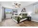 Inviting bedroom boasts a bed with plush green bedding, natural light and mountain decor on the wall at 9675 E Kansas Cir # 45, Denver, CO 80247