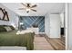 Inviting bedroom featuring a bed with plush green bedding, accent wall and bright natural light at 9675 E Kansas Cir # 45, Denver, CO 80247