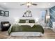 Cozy bedroom featuring a bed with plush green bedding, mountain decor, and bright natural light at 9675 E Kansas Cir # 45, Denver, CO 80247