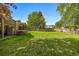 Expansive backyard featuring a large grassy area, mature trees, and a wooden deck, perfect for outdoor activities at 9951 Winona St, Westminster, CO 80031