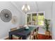 Elegant dining room with modern chandelier, wood table, and large window overlooking greenery at 9951 Winona St, Westminster, CO 80031