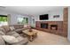 Cozy living room featuring a brick fireplace, large sectional sofa, and natural light at 9951 Winona St, Westminster, CO 80031
