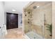 Elegant walk-in shower with dual shower heads, neutral stone tile, and glass surround at 9951 Winona St, Westminster, CO 80031