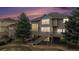 Beautiful evening exterior of the house with a deck, large trees and manicured lawn at 6911 Chestnut Ct, Parker, CO 80134