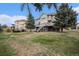 Backyard view of two-story home with a deck and landscaping at 6911 Chestnut Ct, Parker, CO 80134