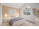 Bright bedroom with an arched window, white furniture, and light tan colored walls at 6911 Chestnut Ct, Parker, CO 80134