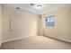 An empty carpeted room with off-white walls, a window, and a ceiling light at 6911 Chestnut Ct, Parker, CO 80134