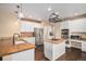 Bright kitchen features granite countertops, an island cooktop, stainless steel appliances, and white cabinetry at 6911 Chestnut Ct, Parker, CO 80134