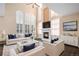 Bright living room featuring soaring ceilings, fireplace, large windows with plantation shutters at 6911 Chestnut Ct, Parker, CO 80134