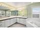 Large main bathroom featuring dual sinks, a soaking tub, and a glass shower at 6911 Chestnut Ct, Parker, CO 80134
