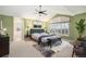 Spacious main bedroom boasts an open en suite bathroom, plush carpet, and a ceiling fan at 6911 Chestnut Ct, Parker, CO 80134