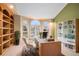 Bright home office with built-in bookshelves, a modern desk, and large windows providing natural light and views at 6911 Chestnut Ct, Parker, CO 80134