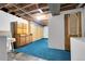 Basement area with storage, laundry hookups, and blue carpeting at 3022 Blackhawk St, Aurora, CO 80011