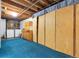 Finished basement area, showcasing exposed ceiling, a storage area, and blue carpet at 3022 Blackhawk St, Aurora, CO 80011