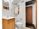 Small bathroom features a toilet, sink, mirror and a door to an adjacent room at 3022 Blackhawk St, Aurora, CO 80011