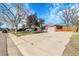 Brick home exterior showcasing a large driveway, attached garage, and well-kept landscaping at 3022 Blackhawk St, Aurora, CO 80011