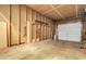 Unfinished garage has wooden beams and a closed garage door, perfect for storage at 3022 Blackhawk St, Aurora, CO 80011