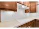 Kitchen backsplash, wooden cabinets, white countertops and oven vent at 3022 Blackhawk St, Aurora, CO 80011