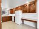 Bright kitchen featuring wooden cabinets, white appliances, tile flooring and countertops at 3022 Blackhawk St, Aurora, CO 80011
