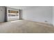 Well-lit living room with neutral carpet and a large window, ideal for comfortable living at 3022 Blackhawk St, Aurora, CO 80011