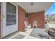 Inviting front porch with seating area and a red brick facade, perfect for enjoying the outdoors at 3022 Blackhawk St, Aurora, CO 80011