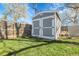 Outdoor storage shed with double doors and green grass at 3022 Blackhawk St, Aurora, CO 80011