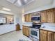 Well-lit kitchen showcasing wood cabinets, stainless steel appliances, and functional layout at 7016 Reed St, Arvada, CO 80003