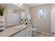 This bright bathroom features a large mirror, window, and neutral finishes at 21210 E Radcliff Pl, Aurora, CO 80015