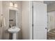 Stylish powder room features a pedestal sink, modern lighting, and an open doorway at 21210 E Radcliff Pl, Aurora, CO 80015