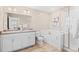 Bright bathroom with double sinks, large mirror, soaking tub, and glass enclosed shower at 21210 E Radcliff Pl, Aurora, CO 80015