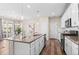 Kitchen with island featuring a sink, white cabinets, stainless appliances, and a seamless flow to the dining area at 21210 E Radcliff Pl, Aurora, CO 80015