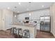 Well-appointed kitchen features an island with bar seating, white cabinetry, and stainless steel appliances at 21210 E Radcliff Pl, Aurora, CO 80015