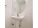 Small white bathroom featuring a pedestal sink, round mirror, and tile flooring at 18807 E 51St Pl, Denver, CO 80249