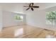 Sun-filled bedroom with hardwood floors, white walls, a ceiling fan, and dual windows for ample natural light at 18807 E 51St Pl, Denver, CO 80249