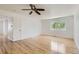 Large bedroom with hardwood floors, white walls, a ceiling fan, and bright window at 18807 E 51St Pl, Denver, CO 80249