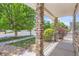 Covered front porch featuring stone pillars and iron railing, offering a welcoming outdoor space at 18807 E 51St Pl, Denver, CO 80249