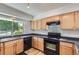 A cozy kitchen featuring light wood cabinetry and modern black appliances under recessed lighting at 18807 E 51St Pl, Denver, CO 80249