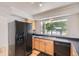 The bright kitchen area showcases wood cabinets and black appliances under a sunny window at 18807 E 51St Pl, Denver, CO 80249