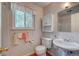 Charming bathroom with decorative wallpaper and a pedestal sink at 6971 S Valentia St, Centennial, CO 80112