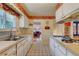 Galley kitchen featuring white appliances and a window with natural light at 6971 S Valentia St, Centennial, CO 80112