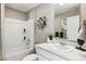 This full bathroom features a shower-tub combo, white cabinets and countertops, and neutral wall color at 4853 Cattle Cross Ln, Castle Rock, CO 80104