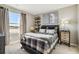 This cozy bedroom features a plaid quilt, a modern nightstand, and a large window offering an expansive view at 4853 Cattle Cross Ln, Castle Rock, CO 80104