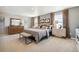 Serene bedroom featuring a large bed, dresser, side tables, and ample natural light from the windows at 4853 Cattle Cross Ln, Castle Rock, CO 80104