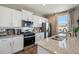Bright kitchen with white cabinets, granite countertops, stainless steel appliances, and modern fixtures at 4853 Cattle Cross Ln, Castle Rock, CO 80104