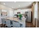 Bright kitchen features granite countertops, stainless steel appliances, white cabinets, and stylish bar stools at 4853 Cattle Cross Ln, Castle Rock, CO 80104