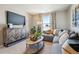 Cozy living room with a large television, decorative cabinet, and stylish curtains with a street view at 4853 Cattle Cross Ln, Castle Rock, CO 80104
