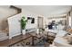 Open-concept living room with modern furnishings, a large plant, and seamless flow into the kitchen at 4853 Cattle Cross Ln, Castle Rock, CO 80104