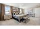 This main bedroom features neutral tones, an upholstered bed, and stylish decor with lots of natural light at 4853 Cattle Cross Ln, Castle Rock, CO 80104
