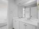 Bright bathroom featuring dual sinks, white cabinetry, and a clean, well-lit vanity area at 9734 Tall Grass Cir, Lone Tree, CO 80124